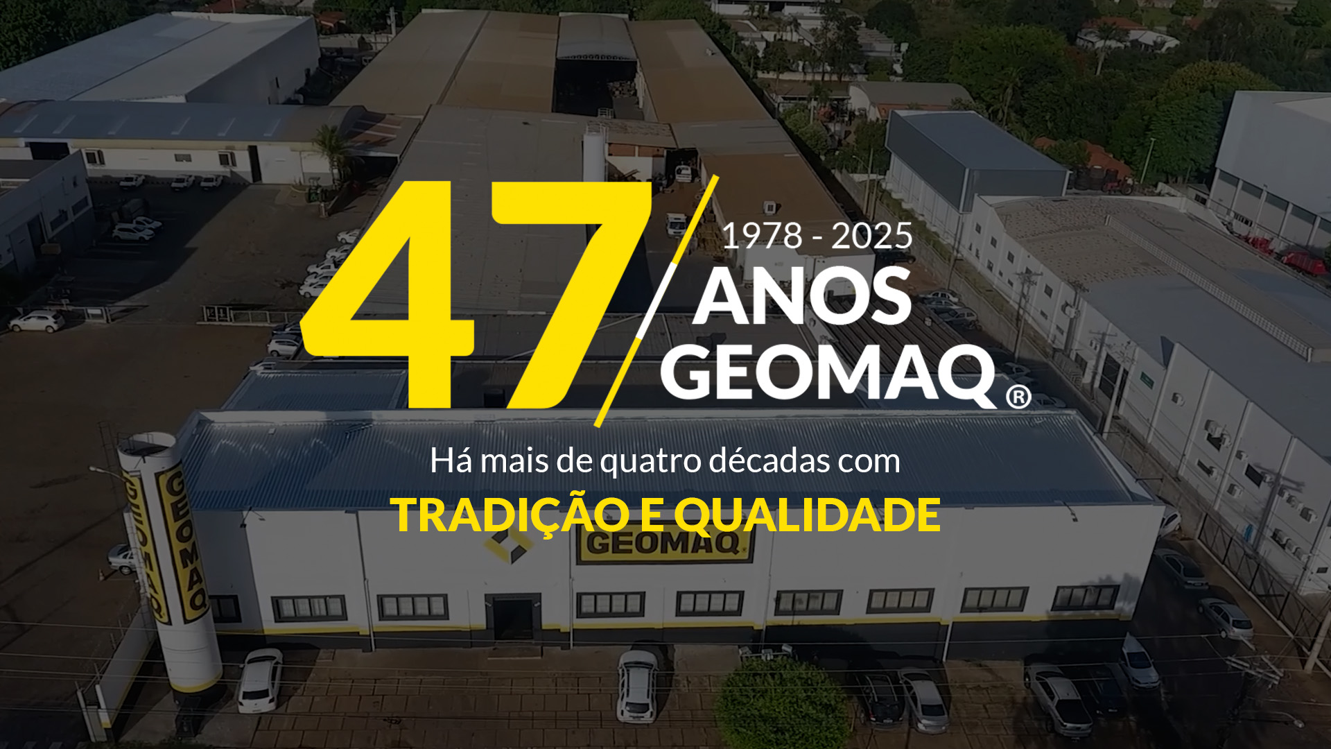 Fábrica da Geomaq vista de cima, destacando a celebração dos 47 anos de 1978 a 2025. O texto em destaque amarelo diz: '47 Anos Geomaq - Tradição e Qualidade'. Imagem aérea corporativa